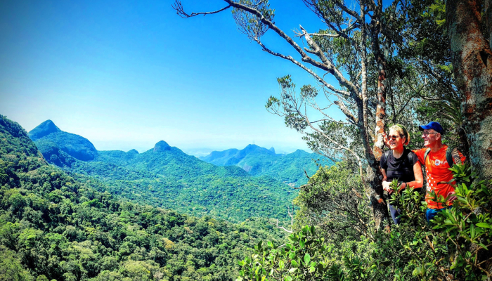 Two hikers in lush green landscape.